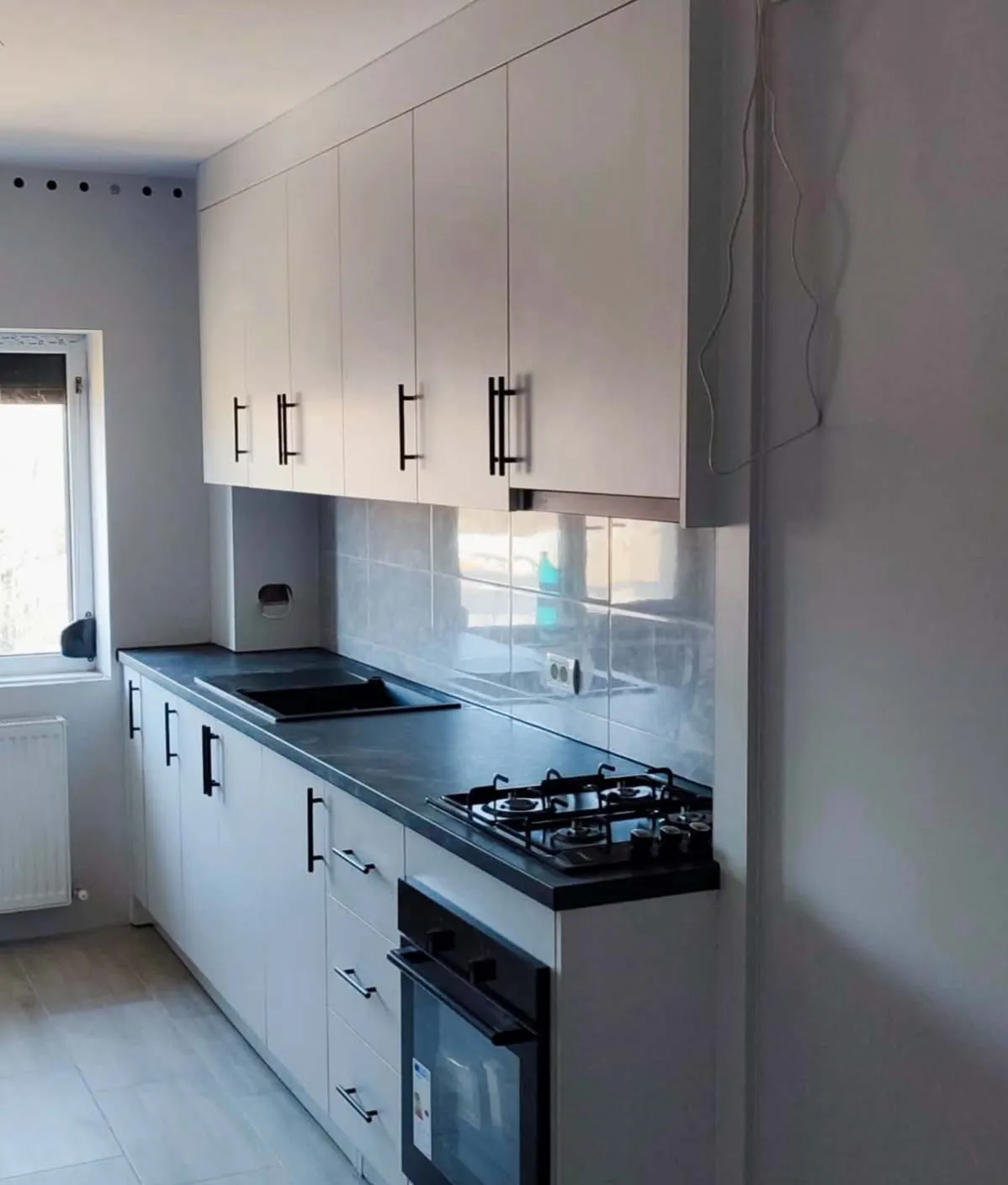 Bucătărie la comandă, croită pe peretele cu fereastră și coloană, într-un apartament